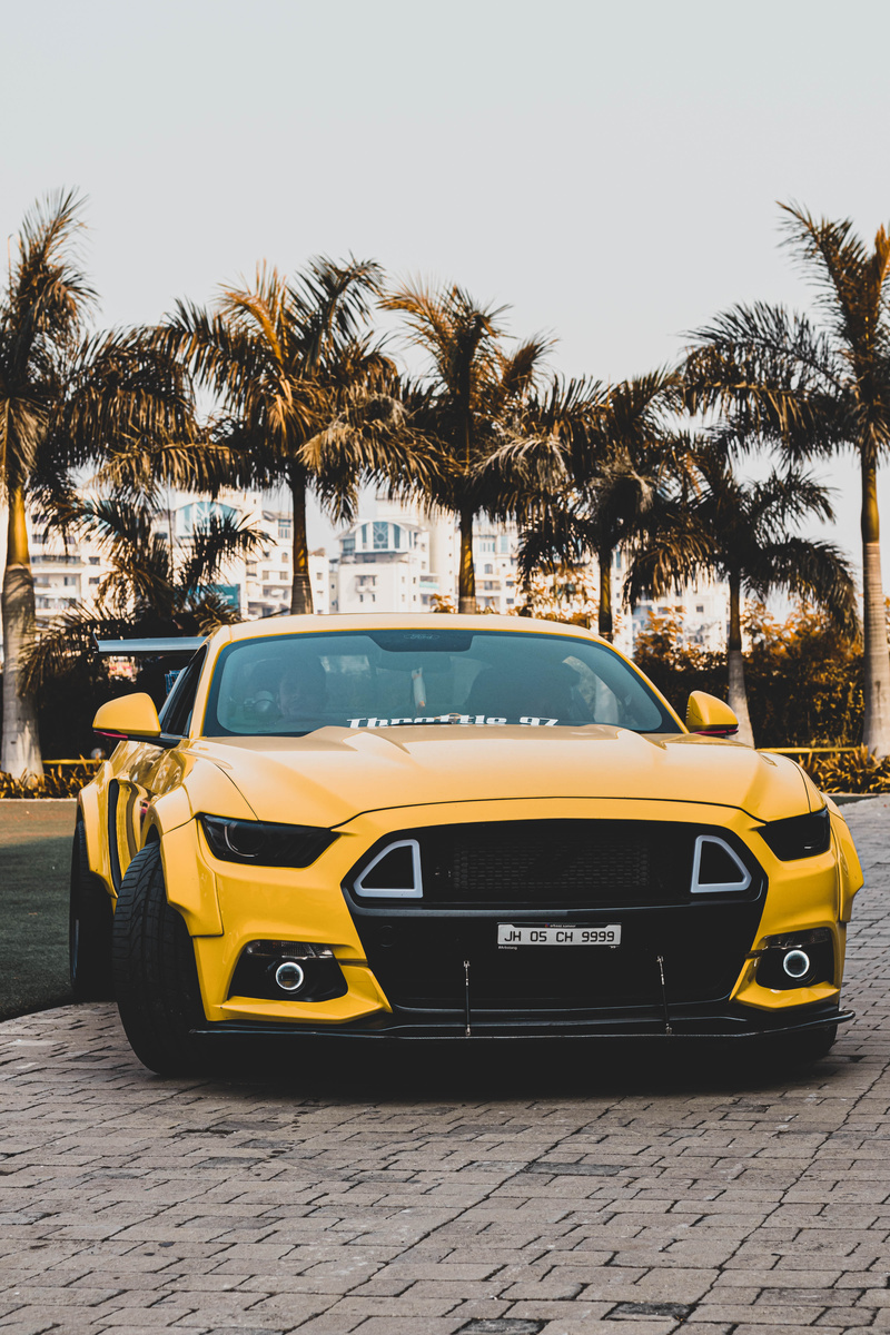 Yellow Mustang Parked Near Palm Trees